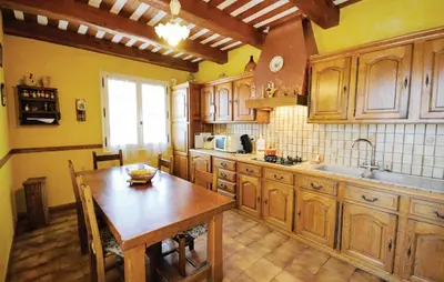 a kitchen with wooden cabinets and a wooden table at 3 Bedroom Amazing Home In Lagnes in Lagnes