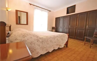 a bedroom with a bed and a table and a window at 3 Bedroom Amazing Home In Lagnes in Lagnes