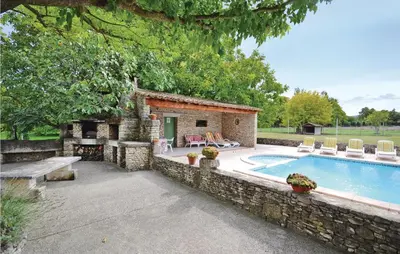 a house with a swimming pool and a stone wall at 3 Bedroom Amazing Home In Lagnes in Lagnes