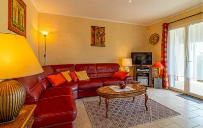 a living room with a red leather couch and a table at Beautiful Home In Lauris With Wifi in Lauris