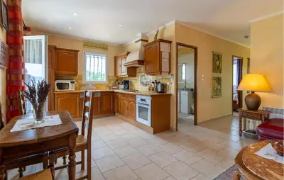 a large kitchen with wooden cabinets and a table at Beautiful Home In Lauris With Wifi in Lauris