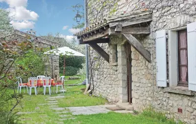 a stone house with a table and chairs in a yard at 3 Bedroom Cozy Home In Sault in Sault-de-Vaucluse
