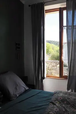 a bedroom with a bed and a window with a view at Chambres d'Hôtes Le relais des marmottes en Luberon in Lagnes