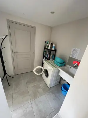 a laundry room with a washing machine and a door at Petite maison près du centre in LʼIsle-sur-la-Sorgue