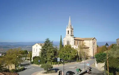 an old church with a steeple on a city street at Cozy Apartment In Bonnieux With Kitchen in Bonnieux