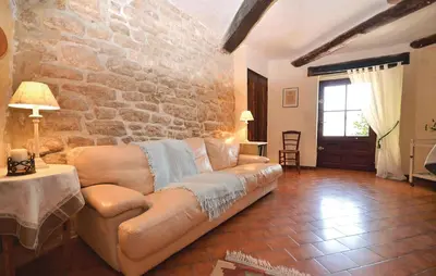 a living room with a couch and a stone wall at 3 Bedroom Nice Home In Bonnieux in Bonnieux