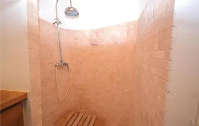 a bathroom with a shower with a tile wall at 3 Bedroom Nice Home In Bonnieux in Bonnieux