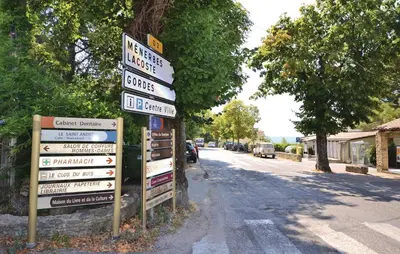 a bunch of signs on a pole next to a street at 3 Bedroom Nice Home In Bonnieux in Bonnieux