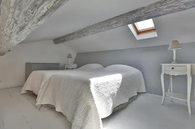 a white bedroom with a bed and a table at Apartments - Experience of PROVENCE in Gordes