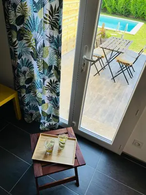 a table in front of a door with a view of a patio at Un coin tropical en Provence ! in LʼIsle-sur-la-Sorgue