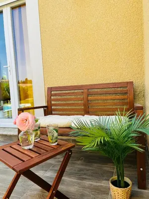 a wooden bench with a table and a potted plant at Un coin tropical en Provence ! in LʼIsle-sur-la-Sorgue