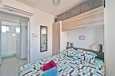 a bedroom with a bed with a wooden headboard at LE PETIT BONHEUR - PLACE PARKING PRIVEE - CLiM - TERRASSE - PISCINE PARTAGEE - PROCHE PARC SPIROU in Saint-Saturnin-les-Avignon