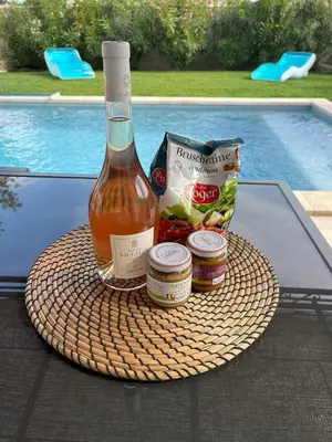 a bottle of wine and some food on a table at Villa Provençale avec Piscine Chauffée in Saint-Andiol