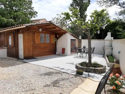 a house with a wooden garage and a table at Chalet au pied du Mont Ventoux in Mormoiron