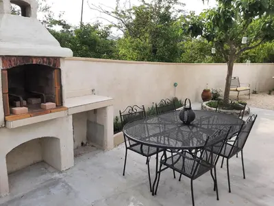 a patio with a table and a fireplace at Chalet au pied du Mont Ventoux in Mormoiron