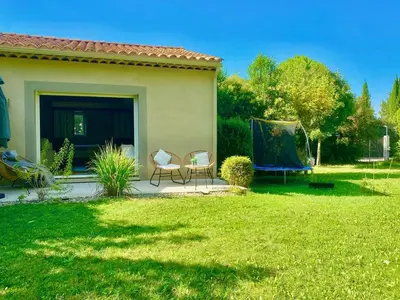 a patio with two chairs and a table in a yard at Appartement neuf et au calme proche Avignon in Althen-des-Paluds