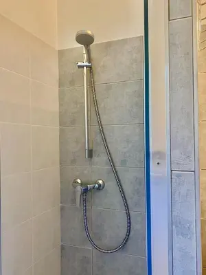 a shower with a shower head in a bathroom at Appartement neuf et au calme proche Avignon in Althen-des-Paluds