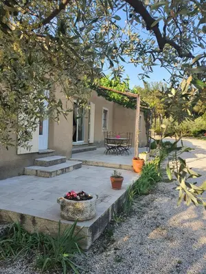 a patio with a table and a basket of flowers at Villa L'Estagniol in Lourmarin