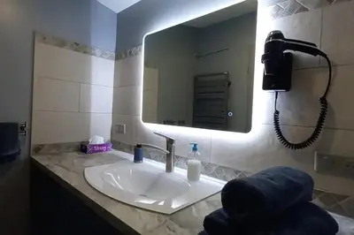 a bathroom with a sink with a mirror and a phone at Logement lumineux, entièrement rénové avec jardin in Caumont-sur-Durance