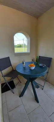 a blue table and chairs in a room with a window at Logement lumineux, entièrement rénové avec jardin in Caumont-sur-Durance