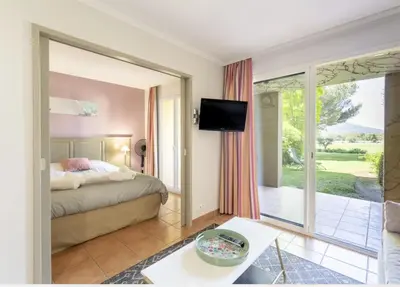 a living room with a couch and a bed at Hôtel du Golf de Pont Royal - appartement paisible rez de jardin - terrasse & piscine in Mallemort