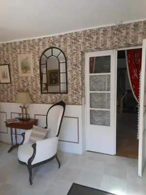 a living room with a chair and a mirror at Les Passiflores in Roussillon