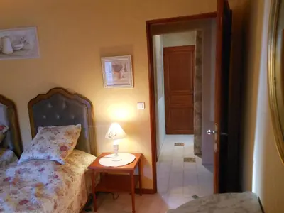 a bedroom with a bed and a table with a lamp at Les Passiflores in Roussillon