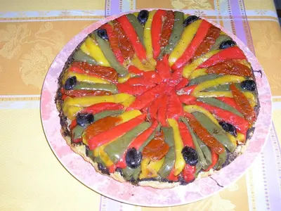 a fruit pizza on a plate on a table at Les Passiflores in Roussillon