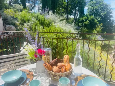 a table with a basket of bread and a bottle of wine at Appart13 piscine chauffée de luxe Belvoir13 à 10 min d Aix in Aix-en-Provence