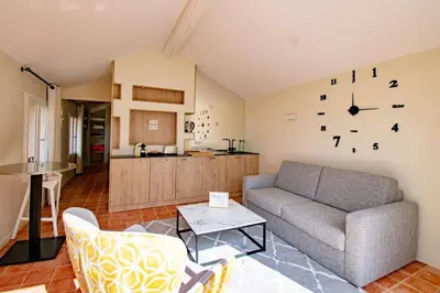 a living room with a couch and a kitchen at Appart13 piscine chauffée de luxe Belvoir13 à 10 min d Aix in Aix-en-Provence