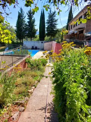 a garden with a pool in the background at Escapade romantique au cœur du Luberon, Piscine, calme et vue magique in Viens