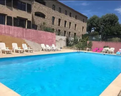 a large swimming pool with chairs and a building at Escapade romantique au cœur du Luberon, Piscine, calme et vue magique in Viens