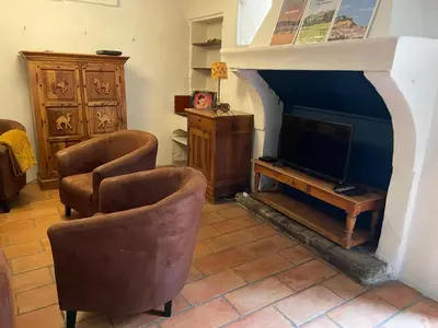 a living room with two chairs and a television at Le Petit Egregore, patio et climatisation in Lauris