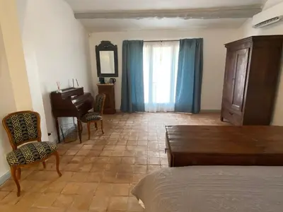 a bedroom with a bed and a table and a piano at L'Insoupçonnée Saint Rémy de Provence by A Pinch Of Soul in Noves