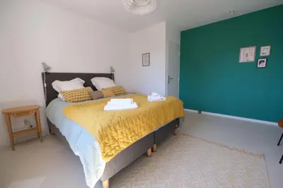 a bedroom with a bed and a green wall at superb villa with private pool, with magnificent view of the luberon, in the heart of provence, 8 persons in Puget