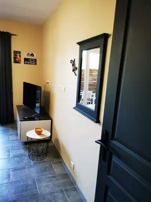 a room with a door and a television and a table at Appartement Indépendant dans le Résid hôtel idéal pour les vacances - séminaires - déplacements pro 