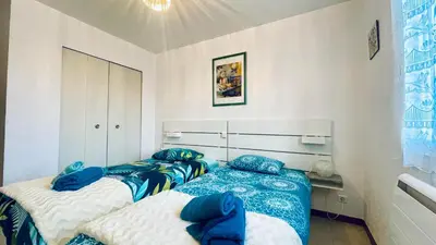 two beds in a room with blue and white sheets at Rendez-vous au soleil de Provence - gite 4 personnes 80m2 - coin jardin - climatisation in Cheval-Blanc