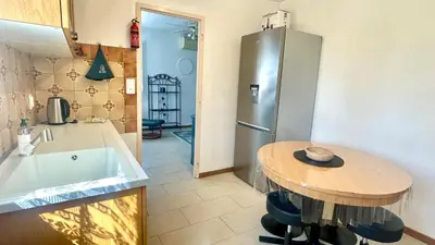 a kitchen with a small table and a refrigerator at Rendez-vous au soleil de Provence - gite 4 personnes 80m2 - coin jardin - climatisation in Cheval-Blanc