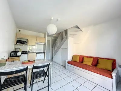 a living room with a red couch and a kitchen at Casa De Provence in Saint-Saturnin-les-Avignon