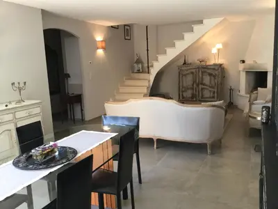 a living room with a couch and a staircase at charmante location vacances avec piscine dans les alpilles, à aureille, proche du centre du village à pied- magnifique vue - 6 couchages. in Aureille