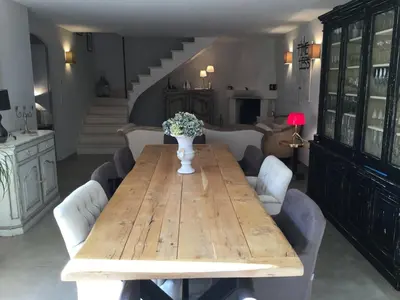 a wooden table with a vase of flowers on it at charmante location vacances avec piscine dans les alpilles, à aureille, proche du centre du village à pied- magnifique vue - 6 couchages. in Aureille