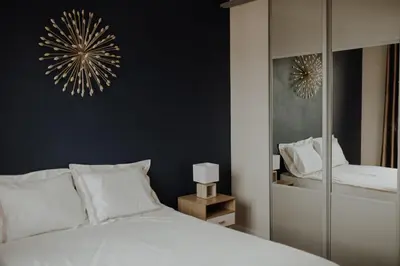 a bedroom with a white bed and a mirror at Superbe appartement rénové - Salon de Provence in Salon-de-Provence