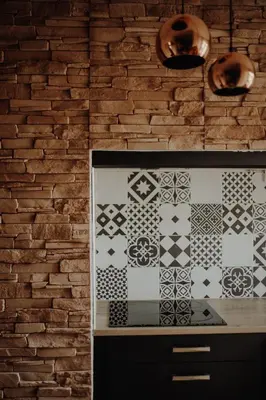 a kitchen with a brick wall and a stove at Superbe appartement rénové - Salon de Provence in Salon-de-Provence