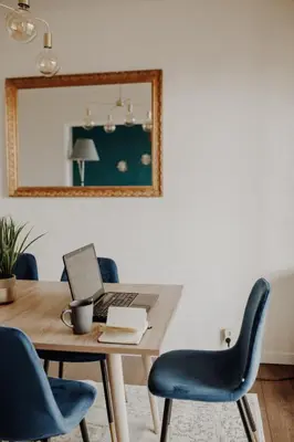 a dining room table with a laptop and blue chairs at Superbe appartement rénové - Salon de Provence in Salon-de-Provence