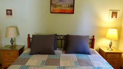 a bedroom with a bed with blue pillows and two lamps at Gîte L'Escapade in Saint-Saturnin-les-Apt
