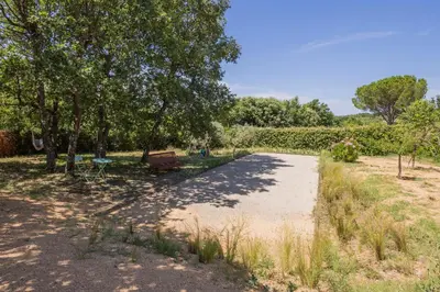 a path in a park with a bench and trees at Gîte L'Escapade in Saint-Saturnin-les-Apt