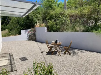 a patio with a table and two chairs and a fence at La bastide in Malemort-du-Comtat
