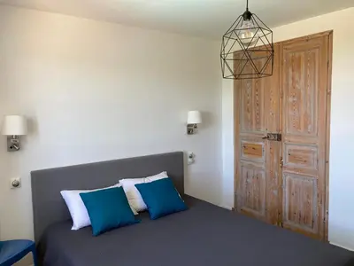 a bedroom with a bed with blue and white pillows at La bastide in Malemort-du-Comtat