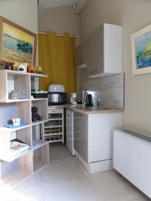 a kitchen with white cabinets and a counter top at Le Clos Martin in Eyragues