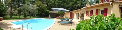 a pool with chairs and an umbrella next to a house at The Blue Tit - private swimming pool in LʼIsle-sur-la-Sorgue